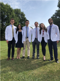 Members of the University of Rochester MSTP cohort gathered outdoors in white coats.